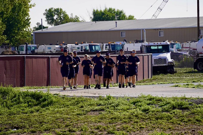 Daytime image of a group of teens jogging outdoors