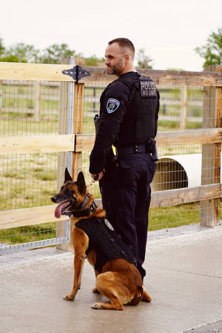 K9 Bolt sitting next to Officer Custodio