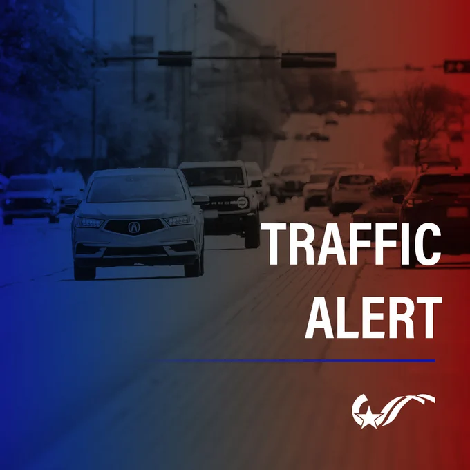 Cars driving on a multi-lane road under traffic lights. The image is overlaid with the text "Traffic Alert" and a red and blue gradient background. 