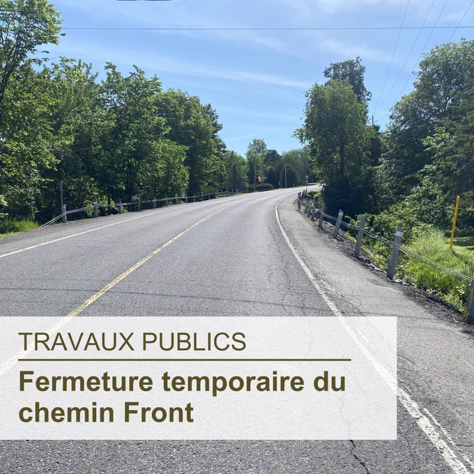 Chemin d'asphalte avec des arbres de chaque côté; le texte superposé en bas à gauche indique « Travaux publics, Fermeture temporaire du chemin Front »