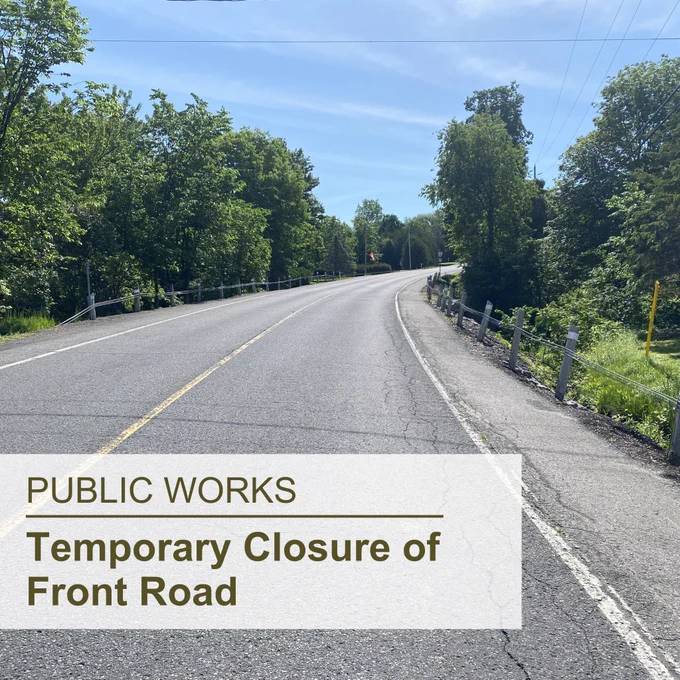 Asphalt road with trees on both sides; the superimposed text at the bottom left reads "Public Works, Temporary Closure of Front Road"