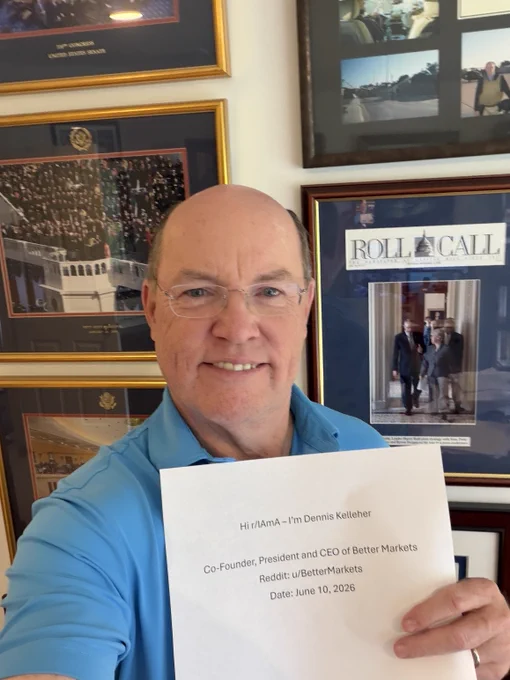 Dennis Kelleher smiles, holding a piece of paper identifying himself.