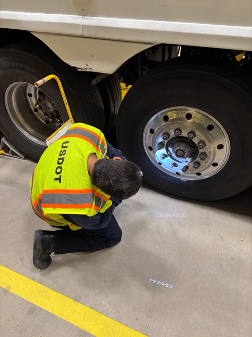 FMCSA safety inspecctor reviews a tire. 
