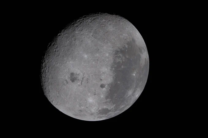 The Artemis II crew was tasked with capturing many key features visible in this image of the Moon, captured on April 6, 2026. The terminator, or the difference in light and darkness, is visible on the top left. The large dark gray area toward center-left is Orientale Basin, while the characteristic dark patches of ancient lava flow we see on the near side are visible on the right half of this image. The Moon stands out against the blackness of space around it. Credit: NASA