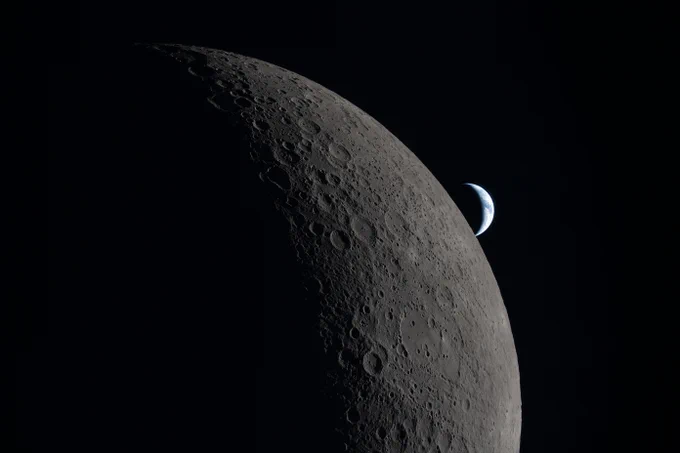 This photo of a crescent Moon and crescent Earth was taken by an Artemis II astronaut during their lunar flyby on April 6, 2026. This image captures one of the final moments before their loss of signal with Earth as the Orion spacecraft flew around the far side of the Moon, reemerging and regaining contact approximately 40 minutes later. Earth can be seen peeking behind the Moon in the distance. The illuminated regions of the Moon and Earth stand out against the blackness of space, while the rest are swallowed in shadow. Credit: NASA