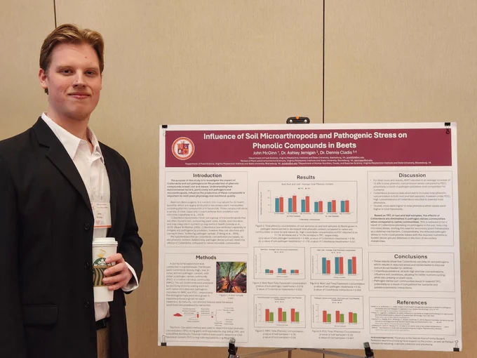 Undergraduate student Johnny McGinn with his research poster, titled "Influence of Soil Microarthropods and Pathogenic Stress on Phenolic Compounds in Beets." 