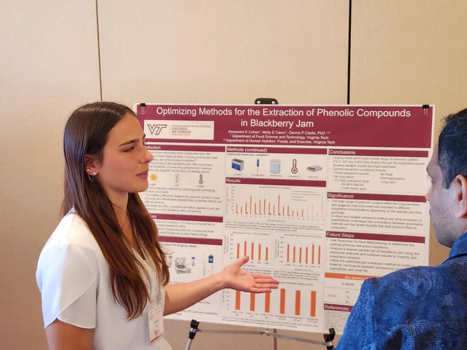 Undergraudate student Alex Cohen with her research poster, titled "Optimizing Methods for the Extraction of Phenolic Compounds in Blackberry Jam." 
