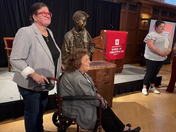 Ryan's mom and sister pose with the bust at the unveiling ceremony. 