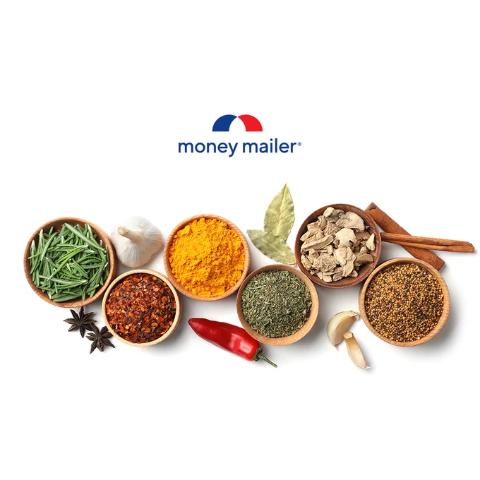 Various spices and herbs arranged in small bowls with a red chili pepper and garlic cloves on a white background.