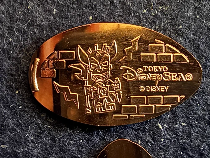 Souvenir medal ("pressed penny") of Shiriki Utundu, from the Tokyo DisneySea Tower of Terror attraction. Text: "Tokyo DisneySea" ©Disney
