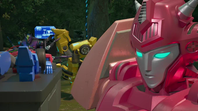Elita-1 stands forlornly in the foreground as Bumblebee is tossed around upside down in the clutches of Airachnid's legs as she attends to Optimus Prime laid back on a table.