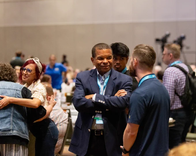 A lively networking event showing people engaged in discussions and socializing. The atmosphere is vibrant and professional.