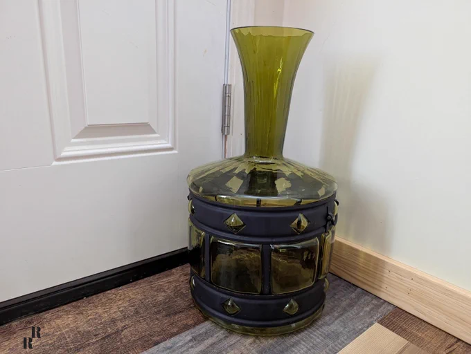 Large avocado imprisoned glass vase with metal frame.