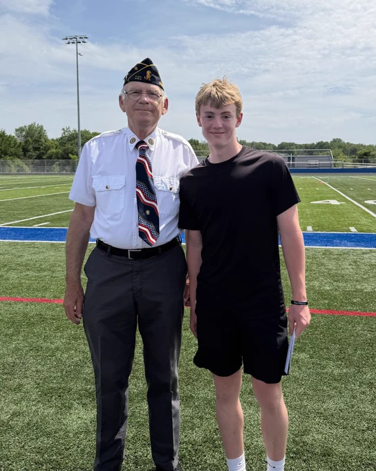Jace Gagnon smiling next to Commander Weinzierl after accepting his Americanism Award