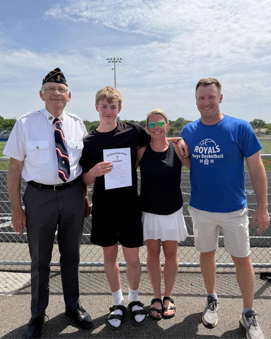 Legion Commander Weinzierl standing with Jace and his parents holding his award. 