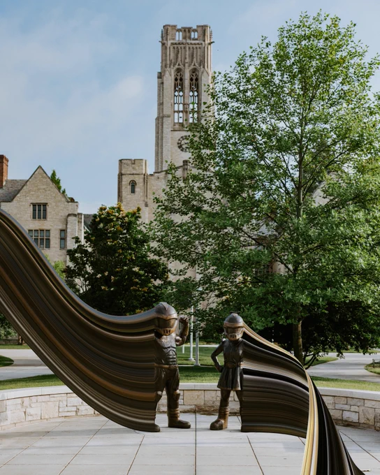 Stone pathway with statues of Rocky and Rocksy as pixels shift out of them left and right.