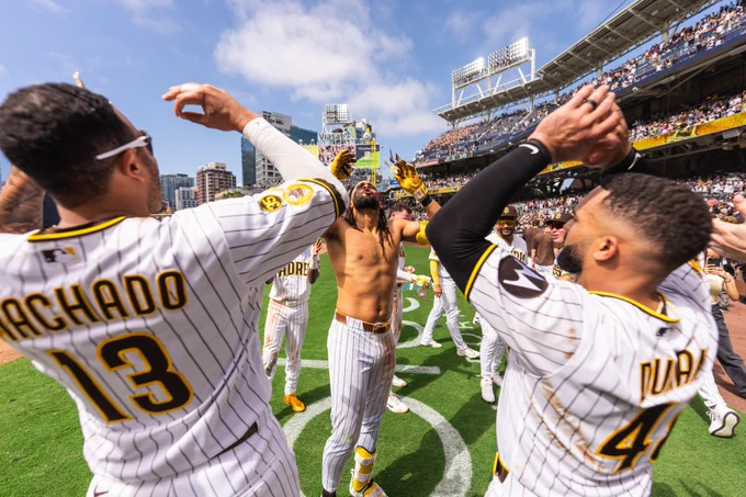 Photo of Manny Machado, Rodolfo Durán, and Fernando Tatis Jr. doing their handshake in celebration of Fernando's walk-off home run.