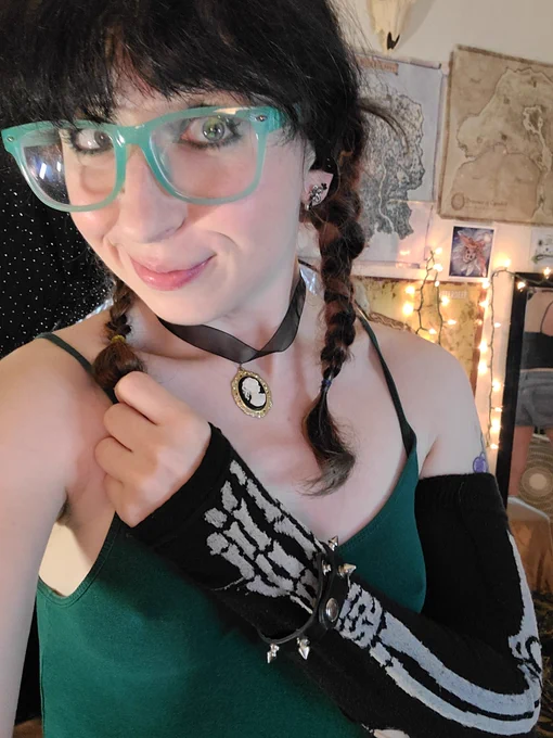Div smiling at viewer wearing a skeleton arm warmer and pigtails 