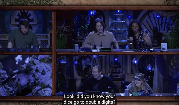A screenshot from C4E014. Aabria says, "Look, did you know your dice go to double digits?" She points towards the camera. Matt looks down smirking slightly and Alex and Ashley wear big grins. Brennan is looking down at something behind his DM screen.
