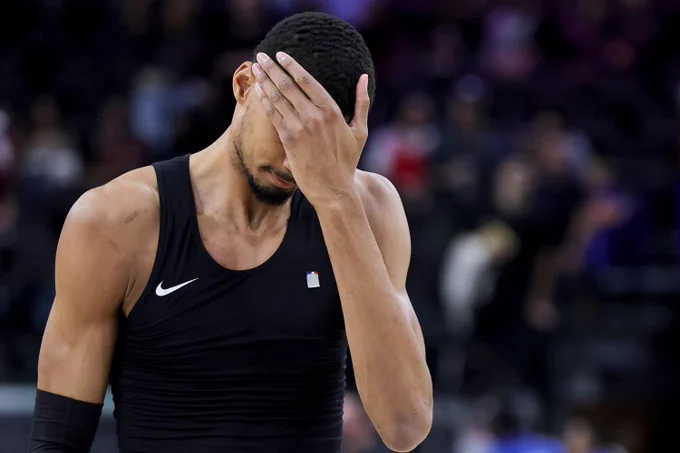 Photo of Victor Wembanyama, San Antonio Spurs superstar, looking dejected and covering his face after a loss.