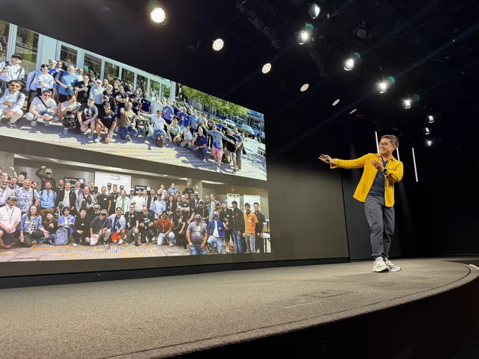 Paolo gesturing to a photo of Step into Vision community members.
