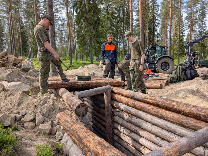 varusmiehet rakentavat juoksuhautaa maastossa