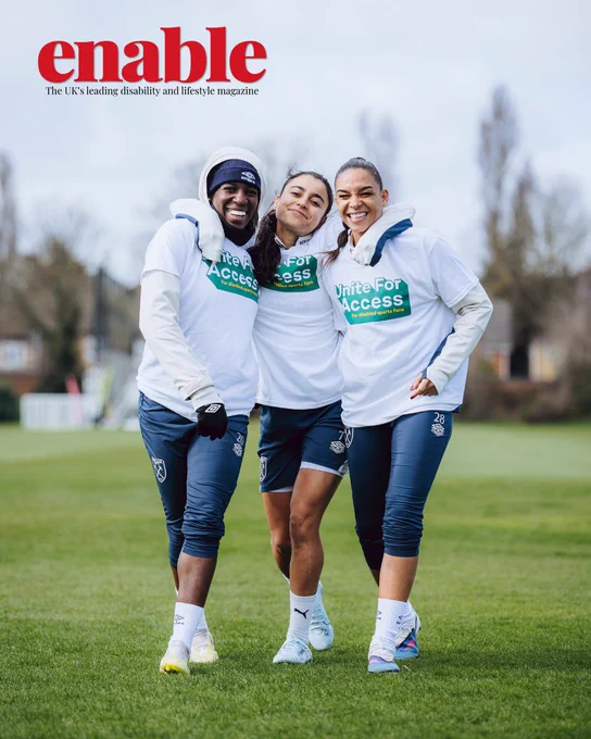 An image of three women on a football pitch. They are smiling and wearing white 'unite for access' sports tops and navy blue joggers and shorts. 