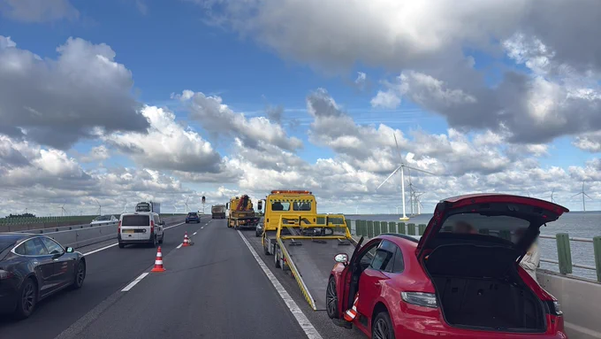 De betrokken voertuigen en bergers staan op de vluchtstrook en rechterrijstrook. Verkeer rijdt via de linkerrijstrook langs het ongeval.