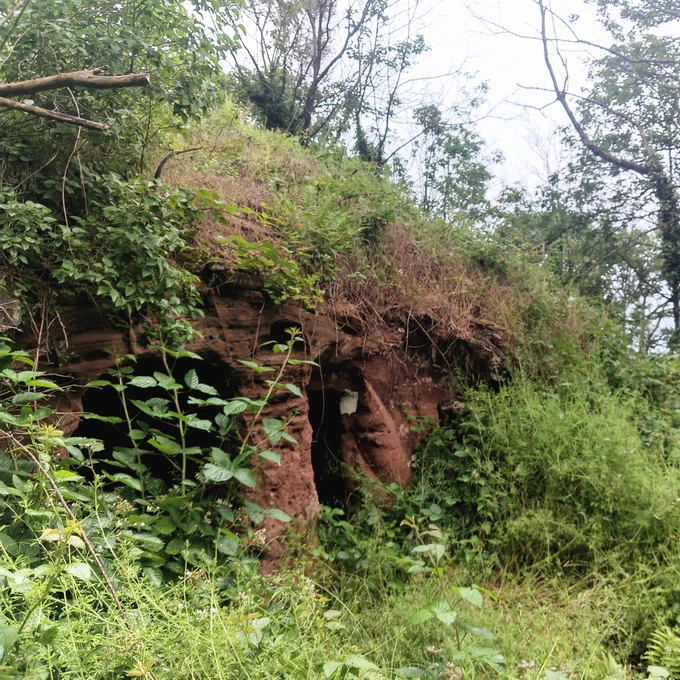 A sandstone rock house in the woods.