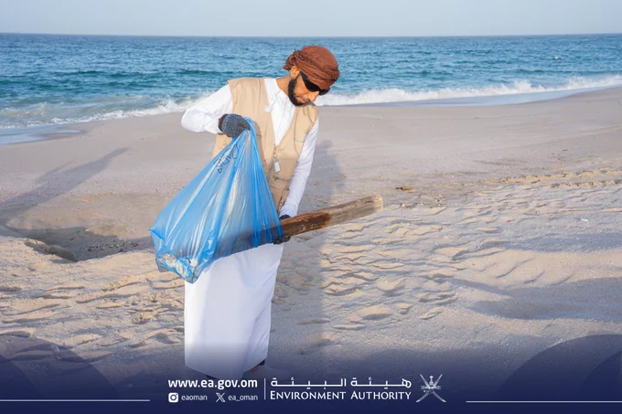 صورة لشخص يجمع نفاية من على الشاطئ.