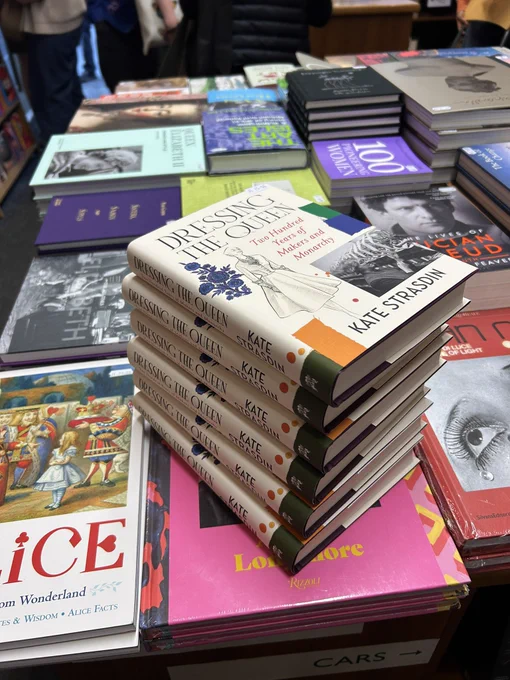 A photograph of a pile of my books, Dressing the Queen, in which I talk about a whole host of makers contributing to Royal wardrobes past