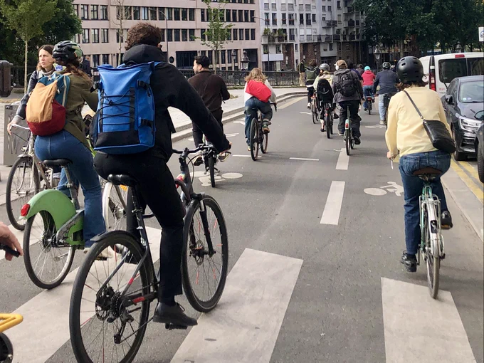 Photo prise dans un "peloton" d'une quinzaine de cyclistes au moins descendant le Quai de Valmy dans le 10ème arrondissement de Paris