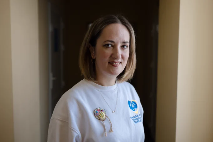 Olena Chaika, director of the Leisure and Social Services Centre for Older People in Synelnykove, stands inside the centre. Established with support from the EU and UNDP, the centre serves as a community hub for older adults and displaced people through creative, educational, and social activities.