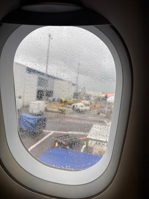 Photo from the airplane window of the rainy tarmac at Edinburgh Airport