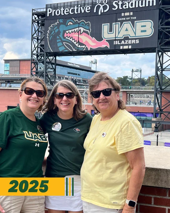 3 UAB fans smiling in front of Protective Stadium