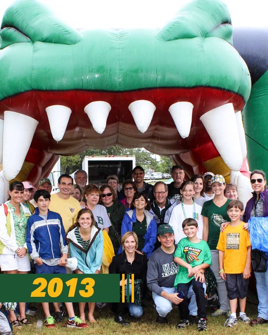 group of UAB fans smiling in front of blow up dragon mouth