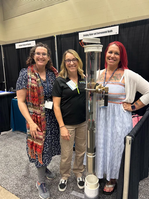 EGLE staff, Kasey, Katie and Danielle from DWEHD, stand with "Wellard the Well".