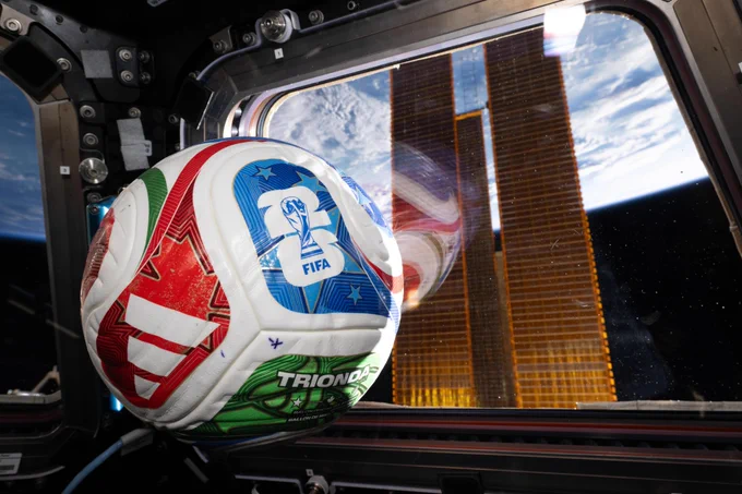 A photo of a soccer ball aboard the International Space Station. Earth and parts of the space station are visible out the window in the background. Credit: NASA