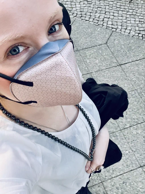 Thirst Masker wearing a black and white outfit and a beige mask.