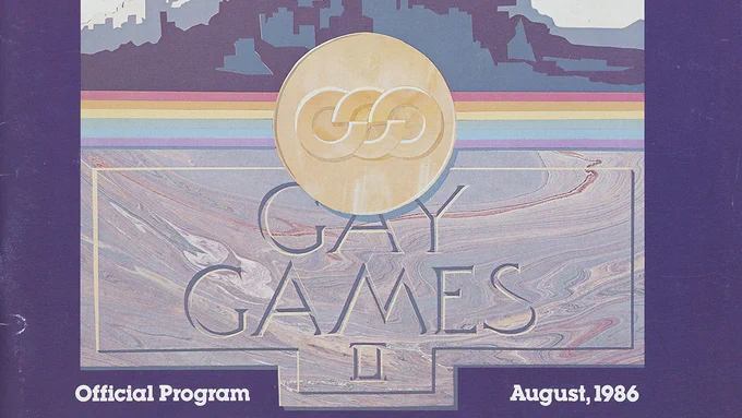A program cover for Gay Games II, with the title on a marble-like rectangle and a gold medal above and a purple background.