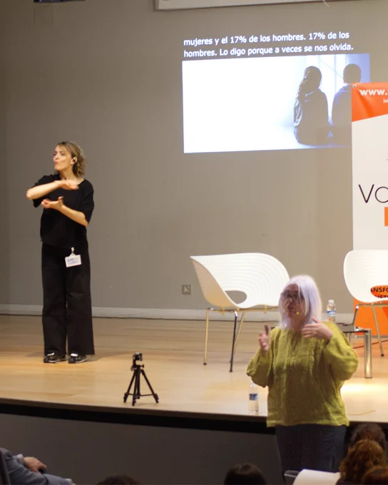 Sobre el escenario la intérprete y al fondo los subtítulos en directo.