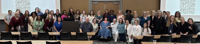 Wide photo of Able SC staff with a large gathering of people who participated in the presentation.
