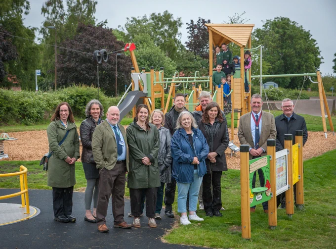 A photo of community members, council staff and local children at the renewed playpark in Athelstaneford.