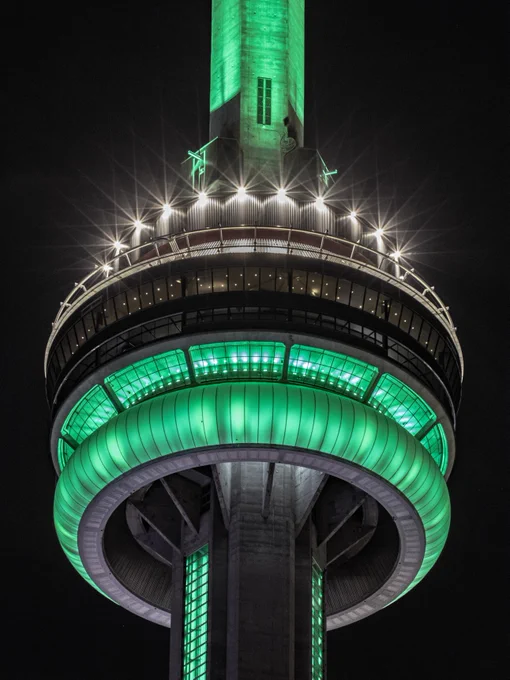 Closeup of the CN Tower at night lit green for Global Fatty Liver Day/ Gros plan de la Tour CN illuminée en vert la nuit 