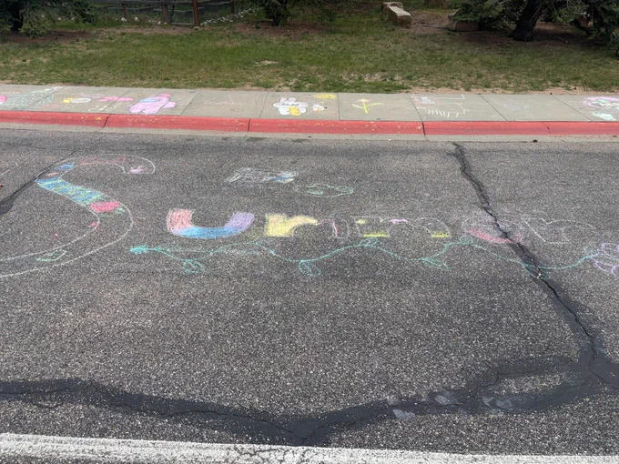 Summer written using sidewalk chalk on the street at Estes Park Elementary during a Mobile Innovation Lab visit.