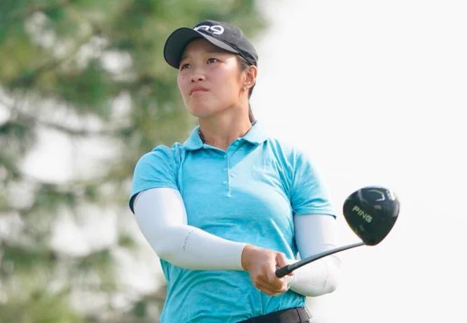 Three images featuring Michigan women's golf professionals during tournament play. Ashley Lau, dressed in a black cap, turquoise polo, white arm sleeves, and dark pants, watches the flight of her tee shot while holding a driver. Monet Chun, wearing a white TaylorMade cap, white short-sleeve polo, and dark skirt, holds her follow-through. Hailey Borja, wearing a navy long-sleeve top with a pink collar and a matching navy Titleist cap, completes her swing with an iron.