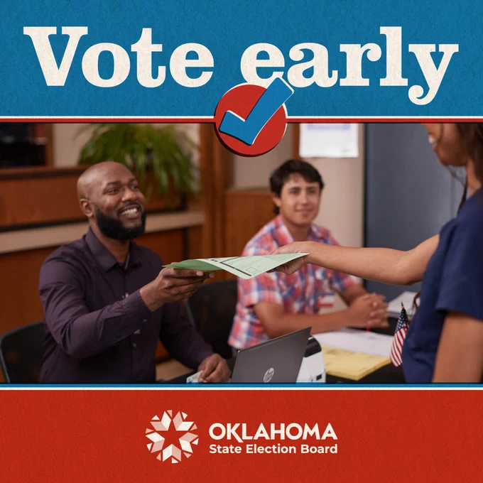 Photograph of a smiling poll worker handing an in-person absentee ballot application to a woman, while another precinct official watches the interaction.