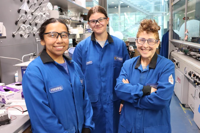Full-color image of three individuals standing in the Stache Lab at Frick Chemistry Lab. 