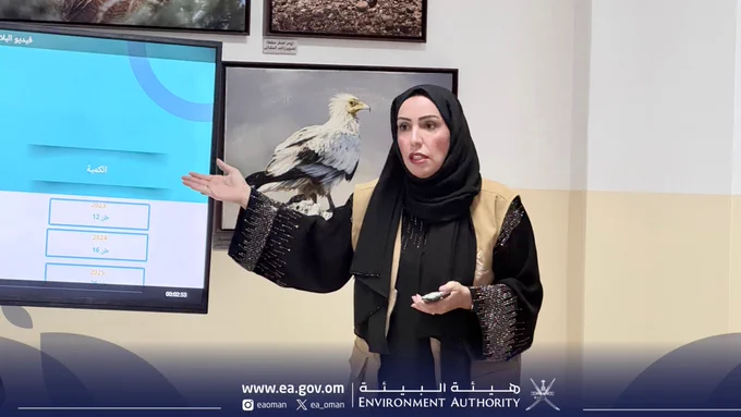 صورة فتاة تقدم عرضاً، وتطهر خلفها شاشة عرض.