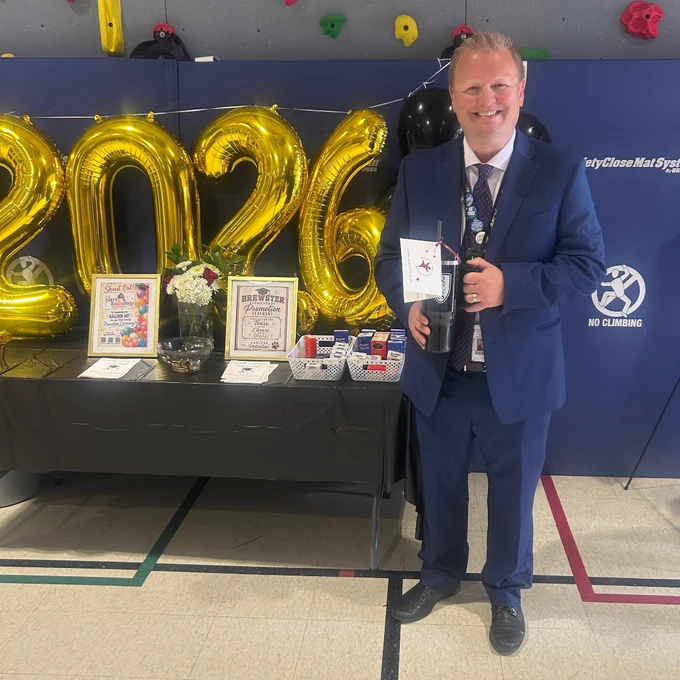Teacher with 2026 balloons, holding a thank you gift. 